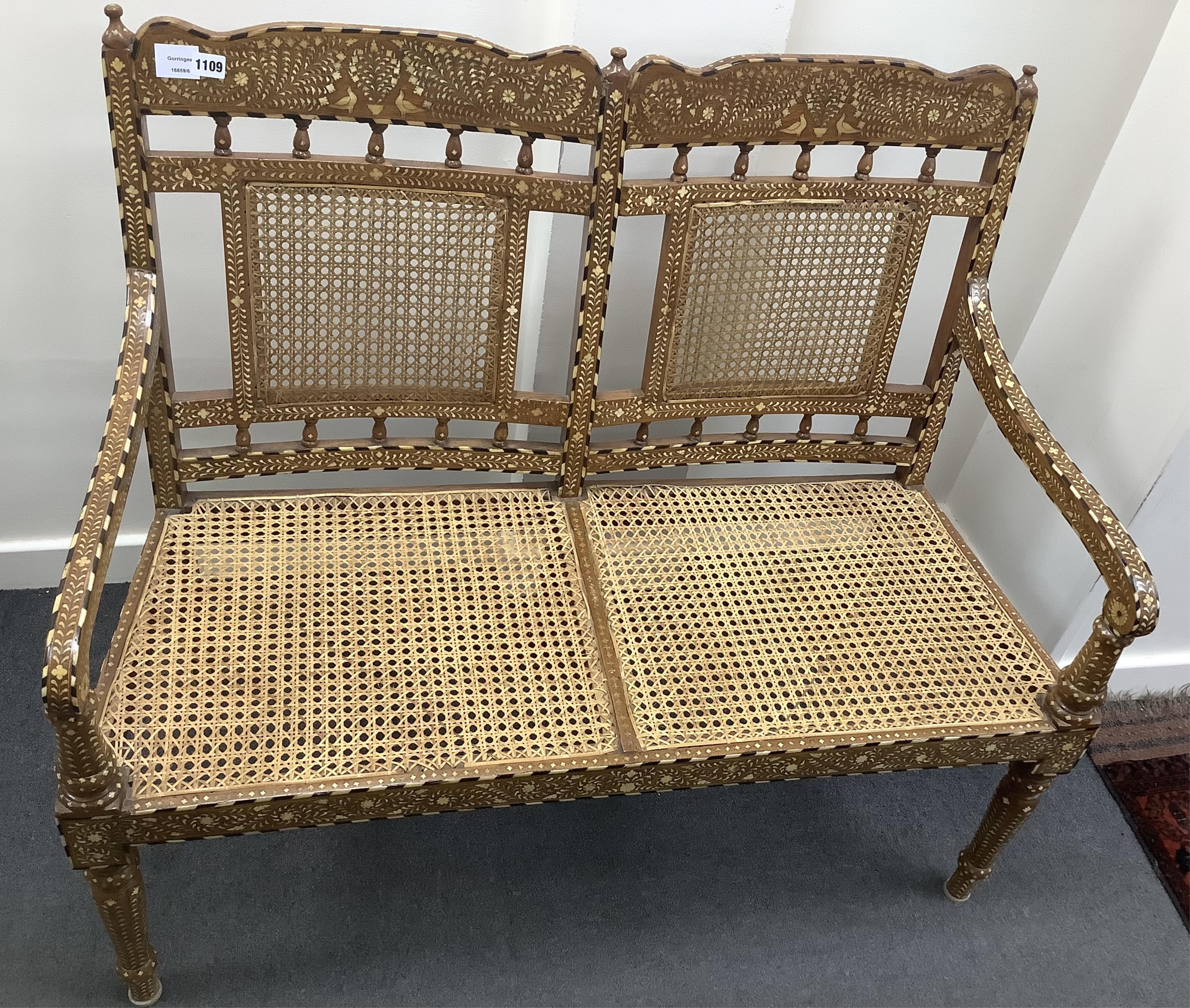 Hoshiarpur, a teak bone inlaid caned settee, width 107cm, depth 48cm, height 97cm. Condition - good